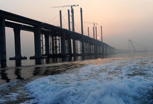 青岛海湾大桥建设进入最后冲刺阶段 建设中的青岛海湾大桥(9月15日摄)。 近日,全长41.58公里的青岛海湾大桥已累计完成投资79.2亿元,占整个工程概算投资(95.3亿元)的83%。大桥下部结构已基本完成,上部结构完成93%。随着大沽河航道桥、红岛航道桥、沧口航道桥的完工,桥面铺装施工已陆续展开,这标志着大桥建设进入了最后的冲刺阶段。据了解,大桥主体工程预计将于2010年年底完成,2011年建成通车。 新华社记者 李紫恒 摄