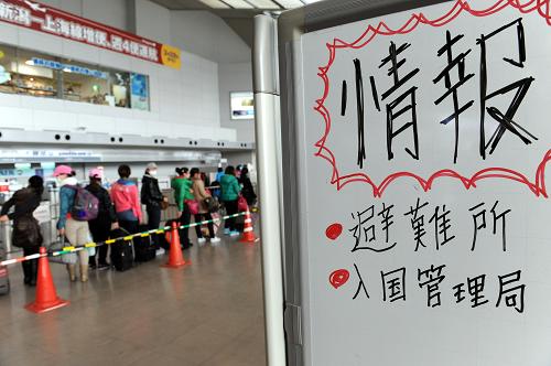 3月20日,在日本新潟机场,暂留新澙临时安置点的中国公民从专用通道办理登机手续。新华社记者 宋振平 摄