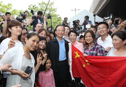 5月21日,中国国务院总理温家宝在日本福岛吾妻综合运动公园体育馆避难所慰问灾民。这是温家宝总理在福岛吾妻综合运动公园体育馆避难所外与当地华人华侨合影。 新华社记者 丁林 摄