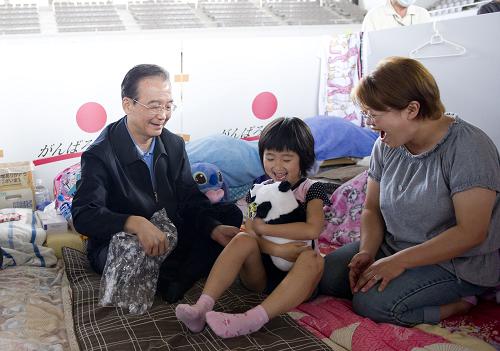5月21日,国务院总理温家宝访问了日本宫城县名取市和福岛县福岛市灾区,代表中国政府和人民向灾区民众表示诚挚慰问。这是温家宝在日本福岛吾妻综合运动公园体育馆避难所慰问灾民时,向避难所里的小女孩赠送大熊猫毛绒玩具。新华社记者 黄敬文 摄
