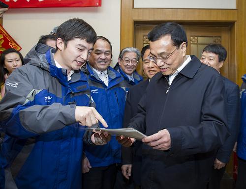 2013年2月7日，中共中央政治局常委、国务院副总理李克强来到国家海洋局，通过卫星视频连线，向正在极地和大洋执行任务的科考队员致以节日问候和新春祝福，看望在京队员和队员家属的代表，并慰问海监工作人员。这是“蛟龙号”的深潜员向李克强赠送海底生物的图片。摄影：新华社记者  王晔