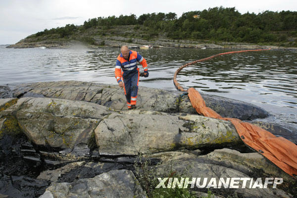 7月31日，在挪威朗厄松附近海岸，挪威海岸警卫队人员拦截泄漏的原油。由于天气原因，一艘在巴拿马注册的油轮7月30日在挪威南部海岸触礁，部分原油泄漏。