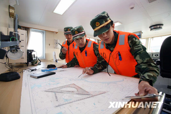 12月4日，海警官兵在新型巡逻舰驾驶舱里绘制海图。