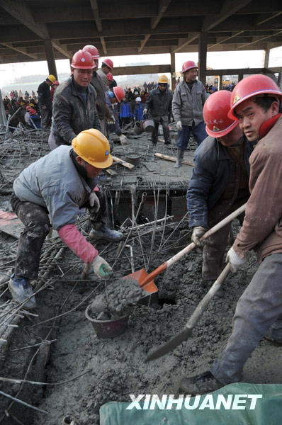 1月12日，几名工人正在清除事故现场的混凝土泥浆。 