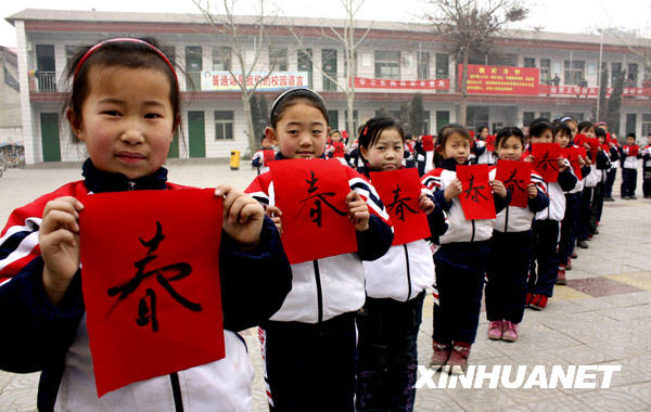 1月19日，河北省广平县明德小学学生展示自己的书法作品 “春”字。
