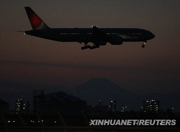 1月19日，在日本东京，一架日本航空公司飞机从富士山上空附近飞过。