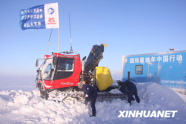 1月20日,中国南极格罗夫山考察队队员正在铲除积雪,防止雪地车被埋。新华社记者 崔静摄