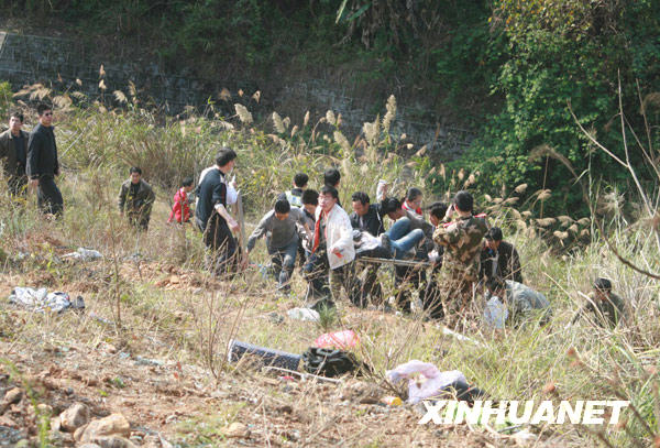2月8日，救援人员在广西河池大客车坠落事故现场运送伤员。