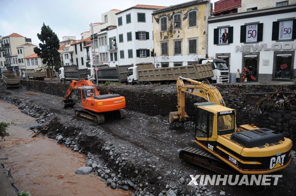 2月24日，葡萄牙马德拉岛首府丰沙尔市内河道内与河道边上停放着用于挖掘淤泥的工程车辆。 