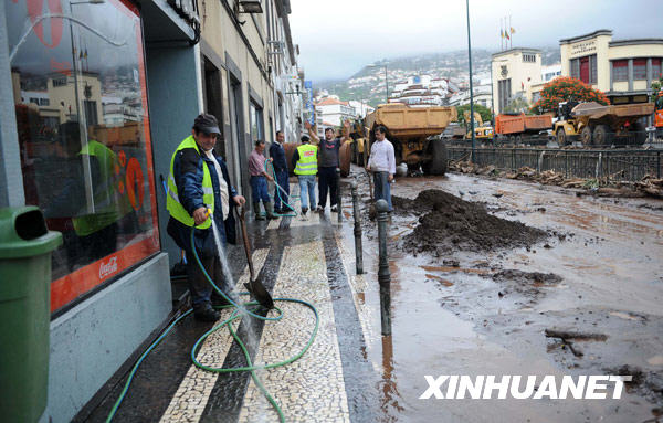 2月24日，在葡萄牙马德拉岛首府丰沙尔市，民众在门前冲洗道路。 