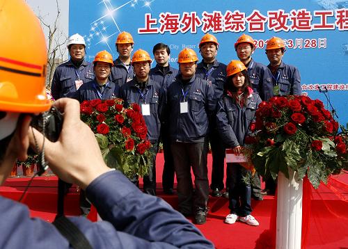 3月28日,部分工程建设者在上海外滩综合改造工程竣工典礼上合影。 当日,经过建设者为期33个月的精心施工,上海市外滩地区综合改造工程全面竣工并向社会开放。此次外滩改造工程涉及外滩通道建设、滨水区改造、渗透墙建造、排水系统改建、公交枢纽和地下空间开发等六大工程项目。 新华社记者陈飞摄