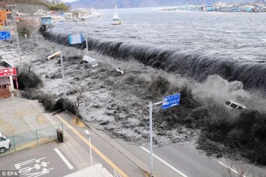 海啸和地震袭击日本后，汹涌而来的海水冲过防洪堤，瞬间淹没黑河入海口附近的一个海滨村庄。