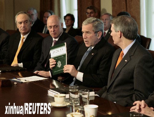资料图片：2007年2月5日，美国总统布什（右二）在首都华盛顿白宫举行的内阁会议上手持一本2008财政年度预算报告。当日，布什向国会提交2008财政年度预算报告时提出总额为7165亿美元的军费申请，其中2351亿美元将用于支持今明两年美国在伊拉克和阿富汗的军事行动。新华社/路透