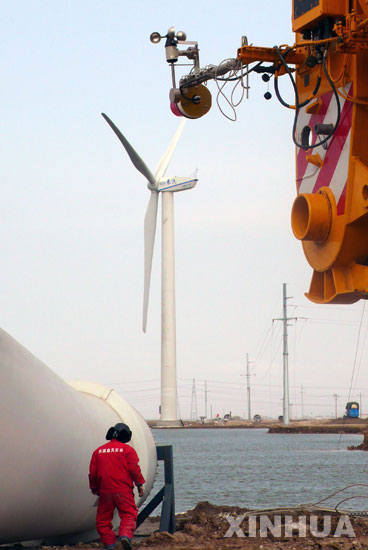 1月9日，一名工人在河北海兴县沿海风力发电设备安装现场施工。 河北省首个沿海风力发电项目――海兴风电场，总装机容量15万千瓦，分三期建设。一期安装33台风力发电机，预计2008年春节前开始发电。 新华社发 (傅新春 摄)