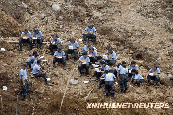 10月13日，在菲律宾拉特立尼达一处泥石流搜救现场，警方救援人员进行短暂休息。菲律宾近日遭热带风暴“凯萨娜”和“芭玛”连续袭击，据救灾部门13日发布的一份报告说，目前已有超过600人丧生。
