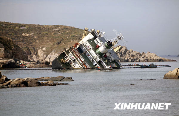 11月6日,清污人员清理事故船只周围的油污。