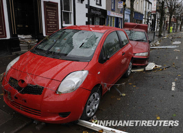 11月22日，在英格兰北部科克茅斯，被洪水侵袭过的汽车停在街头。连续的暴雨导致英国西北部地区一些河流水位上升，引发洪水警报。