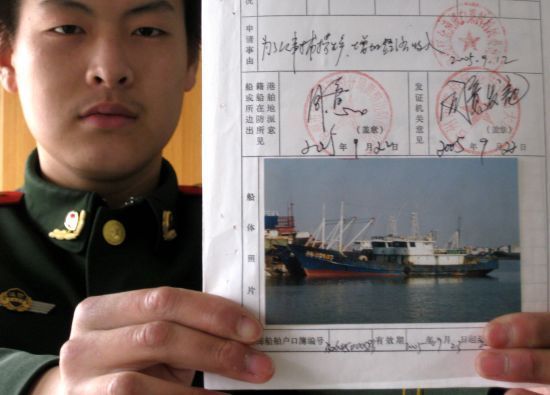 2月28日，浙江台州边防民警展示触礁的“浙路渔2403”船档案。新华社 朱孝钦 摄
