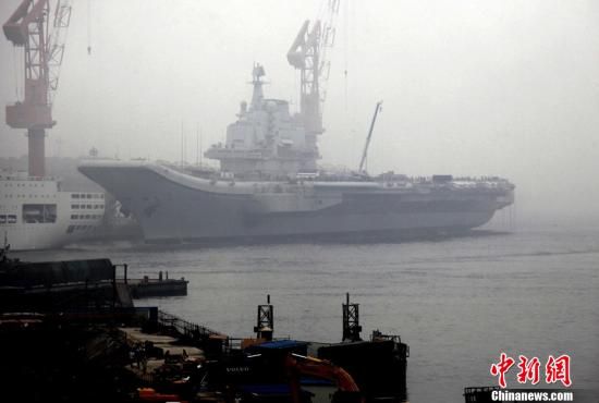 7月27日，中国新闻社记者在大雾弥漫的大连港口拍摄到的中国改建航母。当日，中国国防部新闻发言人耿雁生宣布，中国目前正利用一艘废旧的航空母舰平台进行改造，用于科研试验和训练。中新社发 杜洋 摄
