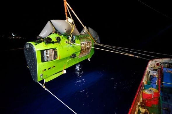 当地时间凌晨2点，一台船载吊车正在将卡梅隆的深潜器吊放入太平洋