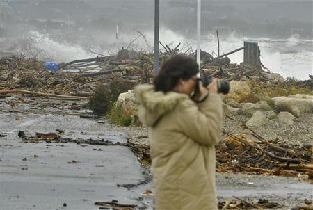 图片说明：2011年11月6日法国南部，一位女性正拍摄拍打在尼斯与昂蒂布之间这段荒芜海岸上的海浪。