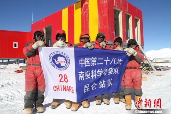 在昆仑站二期工程建设工地上，参与工程建设的全体队员向全国人民拜年。经过两个多星 期的建设，昆仑站二期工程已经完工，并与一期工程建筑连为一体，红黄相间的颜色在蓝天白雪中格外醒目。基础设施建设是南极考察的重要 方面，将为科考项目的开展创造更好的条件。金昶 摄 