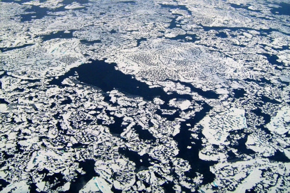 照片展示了北冰洋冰盖上的裂口，海水表层的甲烷从这些裂口释放到空气中
