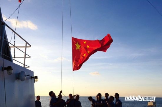 资料图：在黄岩岛巡逻的中国渔政310号船上的渔政执法人员正在升国旗。