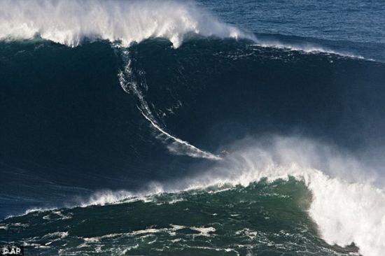来自美国夏威夷州的麦克纳马拉在78英尺高的波浪上冲浪，这是有史以来最大的水墙，出现在葡萄牙纳萨瑞市普拉亚北滩。