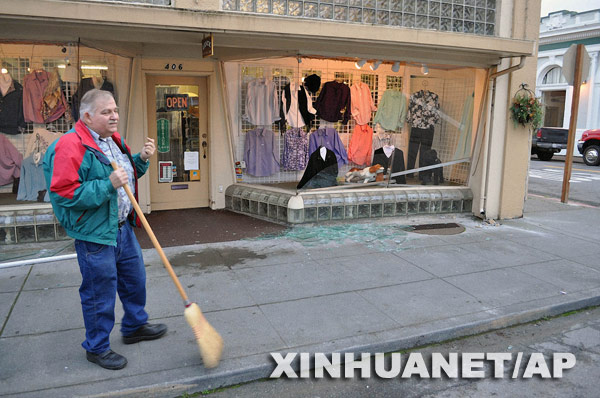  1月9日，在美国加利福尼亚州的芬代尔，店主在地震发生后清扫自家店门口。