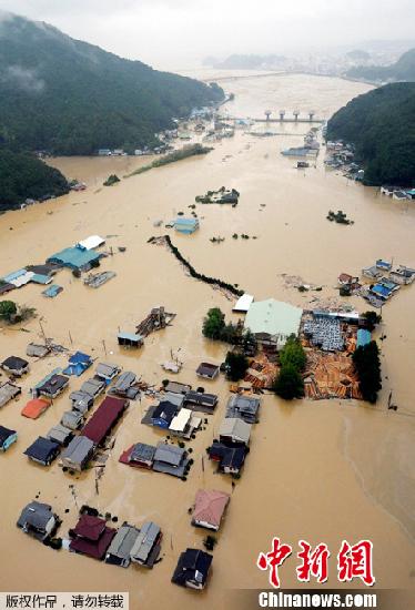 2011年9月4日，日本西部遭受“塔拉斯”台风重创，造成河水暴涨冲走楼房、山崩压毁房屋等灾情，已知至少有27人丧生和54人失踪。图为在日本西部的米氏县，多幢房屋被洪水淹没。