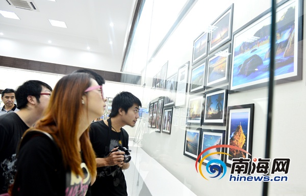 5月3日,2013年首届海南省青年摄影联展在海口市博物馆开展,共展出15名作者的15组150幅摄影作品。图为观众在观看作品。(南海网记者秦彦摄)