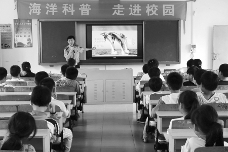一名队员正在给学生们介绍海豚<br>