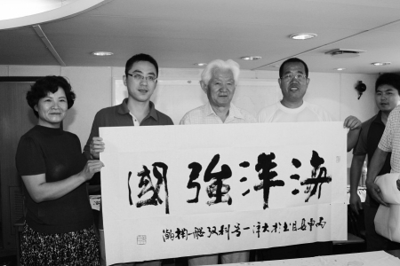 　　图为“大洋一号”船船长徐巍巍（左二）代表船员接受艺术家们赠予的书法作品。 王琳琳 摄<br>