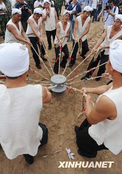 5月27日，一群汉子在黄河岸边表演“黄河号子”。