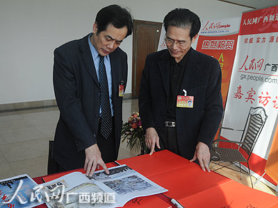 广西北部湾书画院院长、著名画家陈中华委员向人民日报社广西分社社长郑盛丰介绍自己的作品《北部湾啊北部湾》（连波/摄）