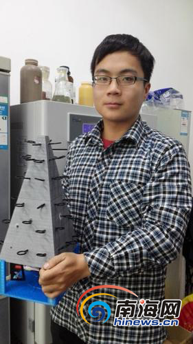 钱军展示这种珊瑚礁基模型。